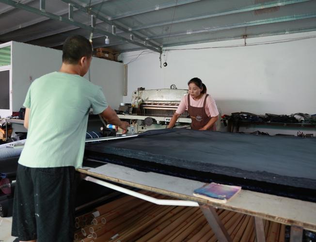 王兰沟村村民王锐夫妇正在进行布料裁剪蕾曼德箱包有限公司销售团队